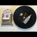 Black pan with gold panning tools and a bag of gold Pay Dirt.