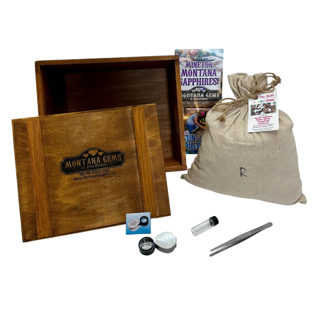 Montana Gems mining kit with wooden box, tools, and sapphire information card on a white background