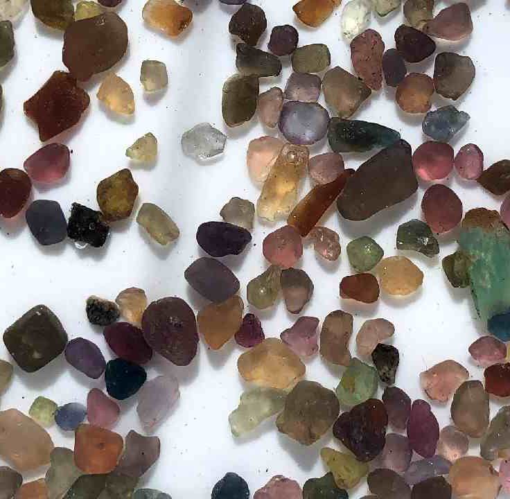 Assorted colored gemstones on a white background